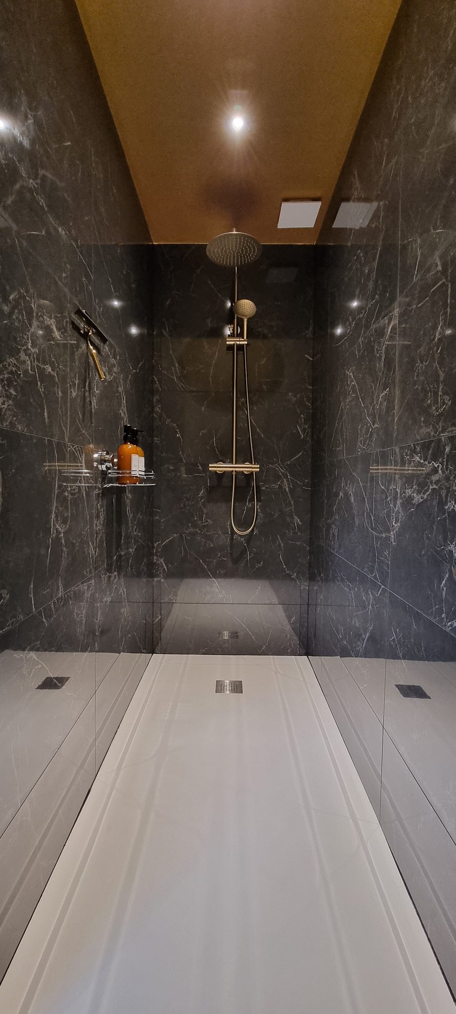 Douche à l'italienne en marbre noir, plafond doré
