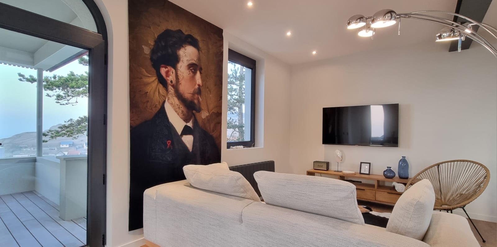 Salon avec portrait d'Oscar Wilde, canapé et terrasse ouverte sur la mer